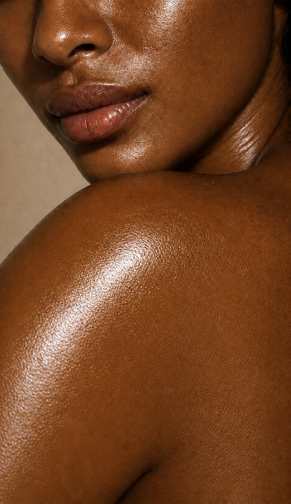 Close-up of luminous, oiled medium-brown facial and shoulder skin